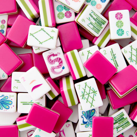 Assorted colorful game tiles with various designs on a pink background