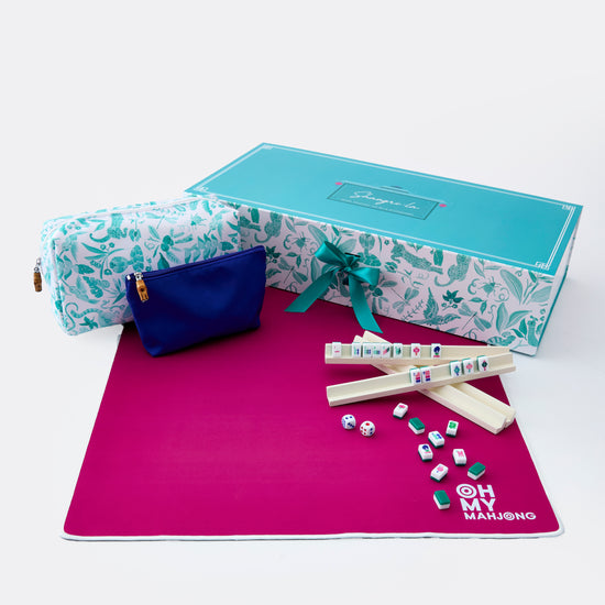 Marble-patterned box with a blue pouch, pink mat, and game pieces on a white background